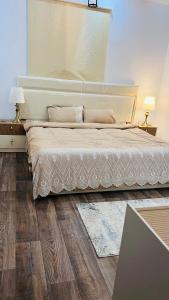 a bedroom with a large bed and wooden floors at شقة رائعة لسياحة في جازان in Jazan