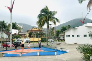 een groep mensen die basketbal spelen op een basketbalring bij Martin de Sá-200 metros da praia in Caraguatatuba