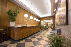 a lobby with a waiting area with potted plants at Real Segovia by Recordis Hotels in Segovia