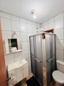 a bathroom with a shower and a toilet and a sink at SunHouse Praia do Rosa in Praia do Rosa +61 photos