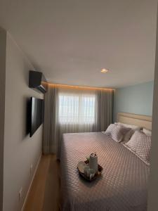 a bedroom with a bed with a tray with a candle at Paraíso Azul em Ponta Negra, Natal RN in Natal