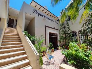 a house with stairs leading to the front entrance at Departamentos Olga in Progreso