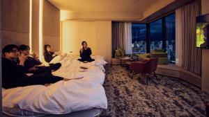 鹿児島市にあるFAV LUX 鹿児島天文館のホテルの部屋のベッドに座る人々