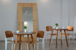 twee tafels en stoelen in een kamer met een spiegel bij Mykonos Chora Residences in Mykonos-stad