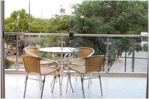 a glass table and chairs on a balcony at Hotel QualitySul in Teixeira de Freitas