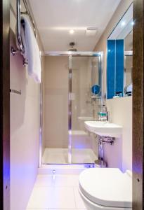 a bathroom with a shower and a toilet and a sink at Seraphine Kensington Olympia in London