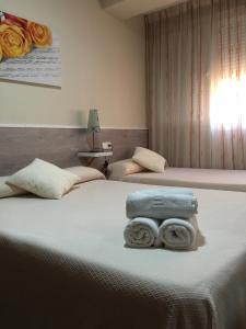 a bedroom with two beds with towels on the bed at Hostal Maribel in Almería