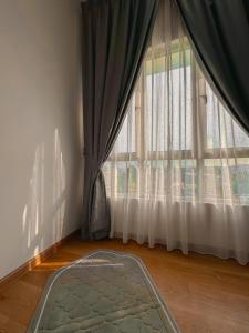 a room with a large window with curtains and a rug at CikguCute Homestay in Kampong Sungai Merab +1 photo