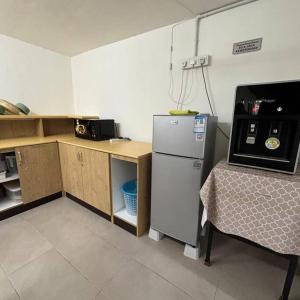 a kitchen with a refrigerator and a counter with a table at Nature Stay at Shah Alam with 4 bedroom 4 bathroom in Shah Alam