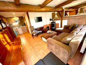 a living room with a couch and a table at Altes Landhaus Oste, Klavier Appartement, 2 Zimmer mit Kamin in Hemmoor
