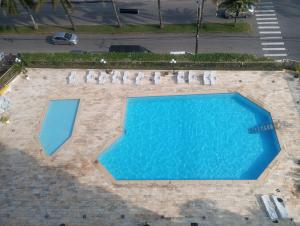Draufsicht auf einen Swimmingpool mit Liegestühlen in der Unterkunft Apartamento com piscina Vista Mar - Mongaguá in Mongaguá + 25 Fotos