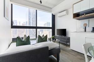 a bedroom with a bed and a large window at Stylish 2BR Apartment with Panoramic City Views in Melbourne