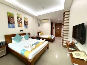 a hotel room with two beds and a television at Sunburn Suites and Rooftop Bar in Coron +14 photos