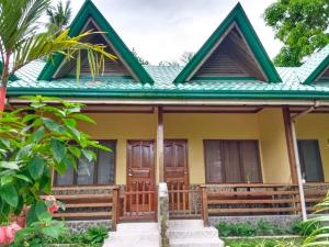 a yellow house with a green roof at Elsa's beach house in Itaytay +7 photos