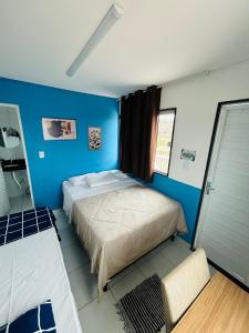 a bedroom with a bed and a blue wall at Flat Rainha da Serra in Bezerros