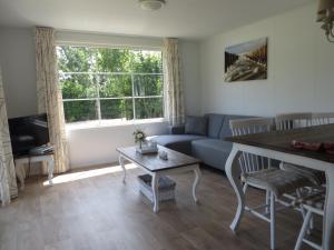 sala de estar con sofá azul y mesa en Boerderijcamping Plantlust, en Veere