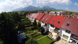 una fila de casas con techos rojos con montañas en el fondo en Apartmany Neuwald, en Nová Lesná