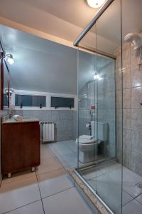 a bathroom with a glass shower and a toilet at Hotel Via Serena in Gramado