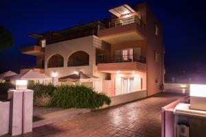 a large building with umbrellas in front of it at night at Casa di Terra in Gythio