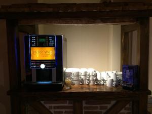 a microwave sitting on top of a table with cups at Le Pavillon in Cours la Ville