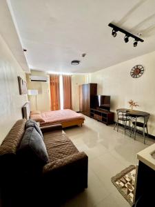 a living room with a couch and a bed and a table at Spacious Condo Unit with Balcony in Lo-oc
