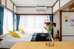 a bedroom with two beds and a vase with flowers on a table at Chelsea Hatsudai 201 CH21 in Tokyo