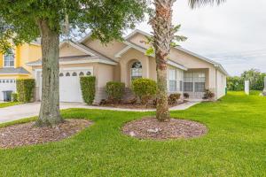 two palm trees in front of a house at Safari Lodge in Orlando