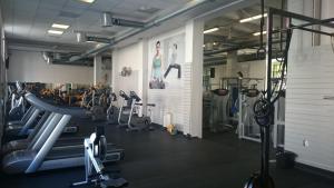 a gym with several treadmills and cardio machines at Hotel Bow Garden in Komárno
