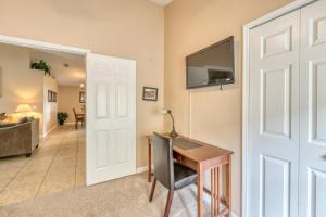 a room with a desk and a tv on a wall at Safari Lodge in Orlando