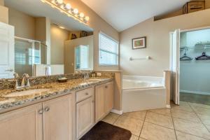 a bathroom with two sinks and a tub and a shower at Safari Lodge in Orlando