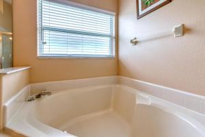 a white bath tub in a bathroom with a window at Safari Lodge in Orlando