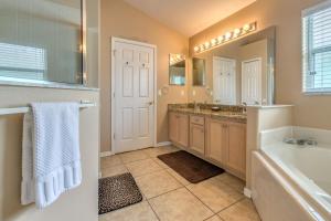 a bathroom with a tub and a sink and a mirror at Safari Lodge in Orlando