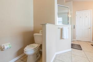a bathroom with a toilet and a mirror at Safari Lodge in Orlando