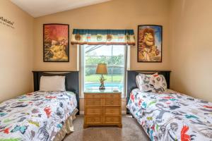a bedroom with two beds and a window at Safari Lodge in Orlando