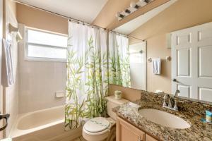 a bathroom with a sink toilet and a shower curtain at Safari Lodge in Orlando