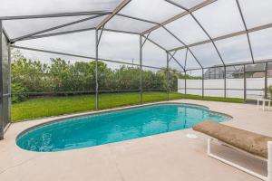 a swimming pool under a metal roof with a swimming poolvisor at Safari Lodge in Orlando