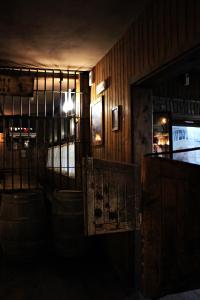 a dark room with a bar with barrels and a television at Cowboys Guest Ranch in Voghera