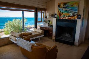 a living room with a fireplace and a view of the ocean at Casa camarones in Camarones