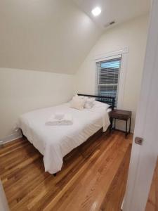 里维尔Cozy Apt, minutes from Boston!的卧室配有一张白色床和木地板