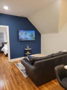 里维尔Cozy Apt, minutes from Boston!的带沙发和蓝色墙壁的客厅