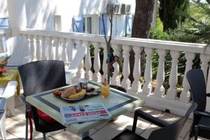 a table with a plate of food on a balcony at Le Sarac Hôtel in Clermont-lʼHérault