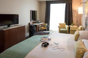 a hotel room with a bed with a tv and headphones at Mercure Sheffield St Paul's Hotel & Spa in Sheffield