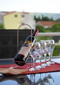 una bottiglia di vino e due bicchieri di vino su un tavolo di Red Sunset Apartments a Kaštela (Castelli)