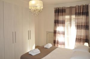 a bedroom with a bed and a chandelier and a window at Casa Tony in Rome