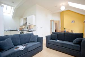 a living room with two couches and a kitchen at The Pyjama Factory in Bushmills