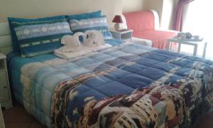 Un dormitorio con una gran cama azul con toallas. en Ricomincio Da Qui, en Nápoles