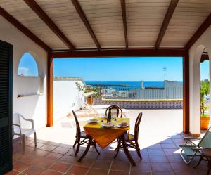 - une table et des chaises sur une terrasse avec vue sur l'océan dans l'établissement Leuca Residence, à Leuca