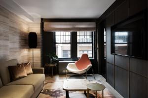 un salon avec un canapé et une chaise dans l'établissement The Time New York, part of JdV by Hyatt, à New York