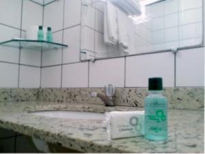 a bathroom with a sink and a bottle of soap at Campus Liberdade Flat in Belo Horizonte