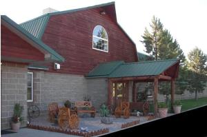 a red barn with chairs and a patio in front of it at Buffalo Lodge in Chugwater